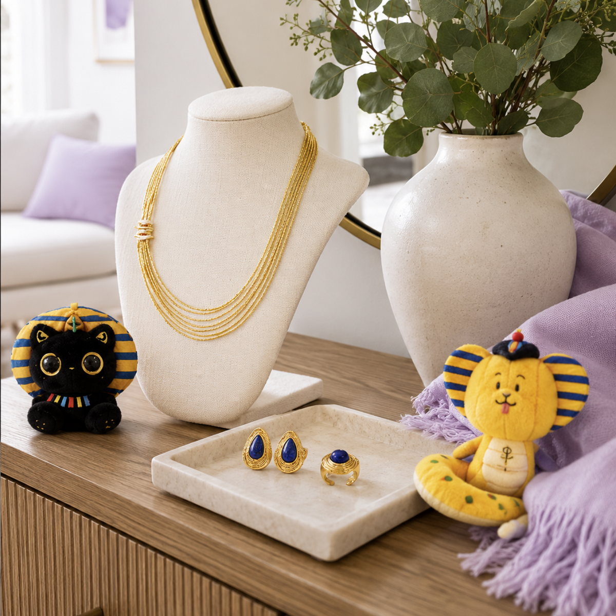 Egyptian art collection hero image with gold jewelry, Egyptian-inspired plush charms, and home decor