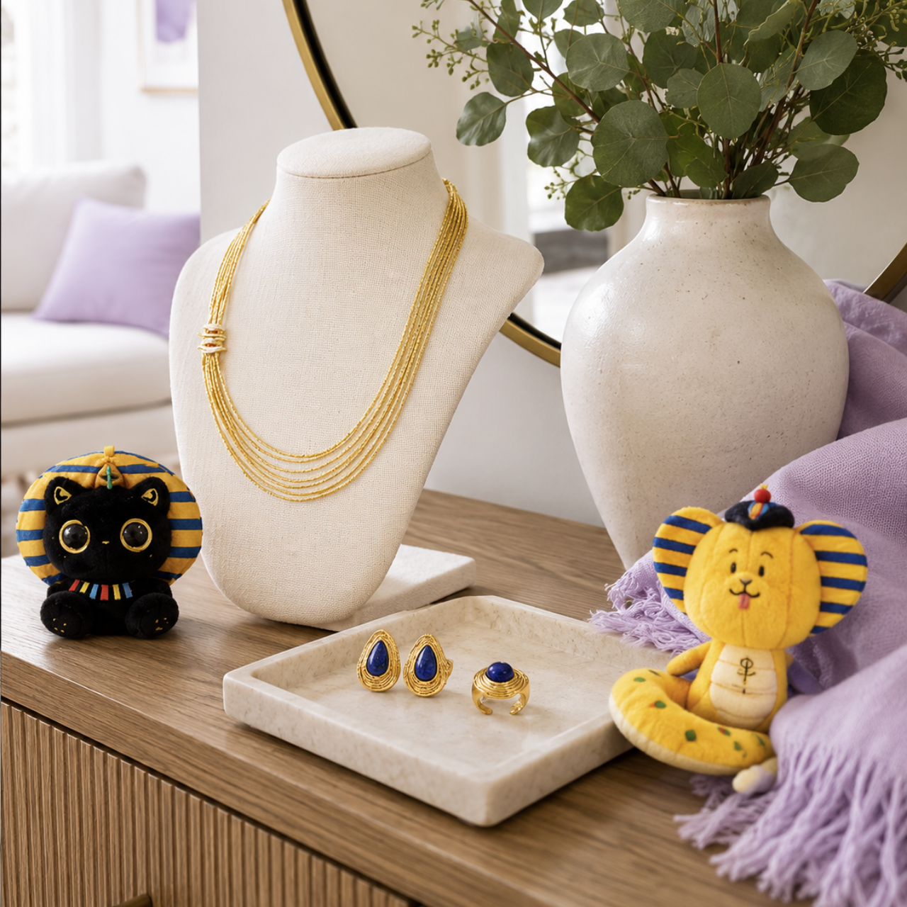 Egyptian art collection hero image with gold jewelry, Egyptian-inspired plush charms, and home decor